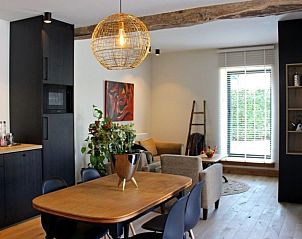 Gezellige eetruimte in Het Koerhuis, Kinrooi, met houten tafel en moderne inrichting, ideaal voor een ontspannen vakantie in Limburg.