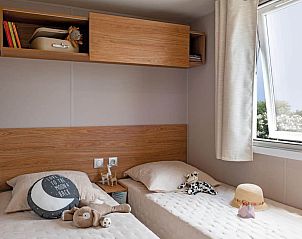 Gezellige slaapkamer in Chalet in Kinrooi, Limburg, Belgi met uitzicht op de natuur door een open raam.