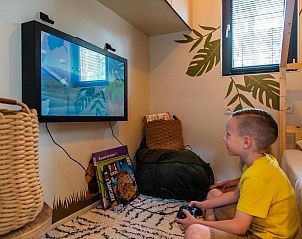 Child enjoys games at Kids Adventure cottage, a vacation home in Zutendaal, Limburg, Belgium, with indoor play area.