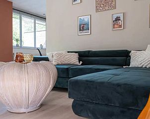 't Bunga huiske vakantiehuis in Rekem, Limburg biedt een stijlvolle woonkamer met comfortabele zithoek en decoratieve accenten.