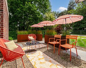 Geniet van het zonnige terras bij Maison Clement, een vakantiehuis in Maasmechelen, Limburg, omgeven door groene natuur en comfortabele zitjes.