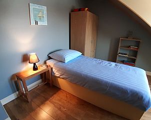 Eenpersoonskamer in De Maaskei vakantiehuis, Kinrooi, Limburg met een comfortabel bed en warme verlichting.