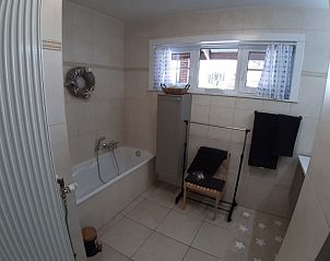 Badkamer met ligbad in De Maaskei vakantiehuis, Kinrooi, Limburg voor ultieme ontspanning na een dag verkennen.