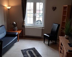 Stijlvolle zitkamer in De Maaskei vakantiehuis, Kinrooi, Limburg met een gezellige inrichting en uitzicht op de tuin.
