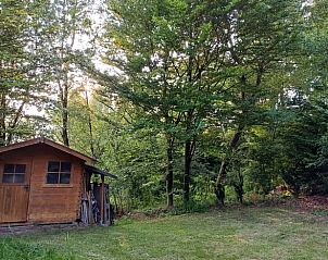 Rustikales Ferienhaus in Bllingen, Ardennen, umgeben von grner Natur und Bumen, ideal fr einen entspannten Aufenthalt in Lttich, Belgien.