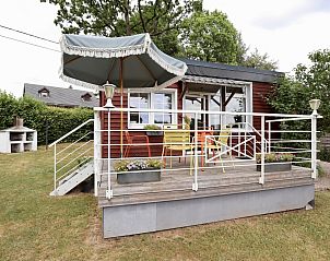 Veranda van chalet Sous les Hetres in Robertville, Ardennen, Belgi met kleurrijke stoelen en parasol, omringd door natuur.