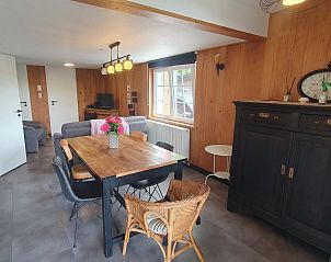 Gezellige woonkamer van chalet Sous les Hetres in Robertville, Ardennen, Belgi, met houten interieur en uitnodigende eetruimte.