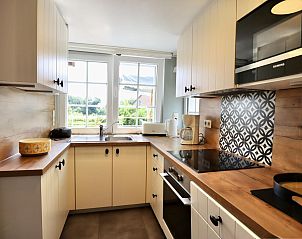 Moderne keuken in chalet Sous les Hetres, Robertville, Ardennen, Belgi met uitzicht op de groene omgeving.