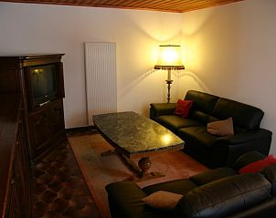 Cozy living room with leather sofas in Herresbach vacation home, Ardennes, Belgium.