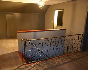 Spacious hall with elegant staircase in vacation home Herresbach, Ardennes, Belgium.