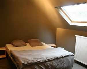 Comfortable bedroom with skylight in Herresbach cottage, located in the Ardennes.