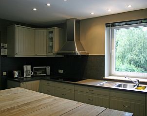 Modern kitchen with wooden dining table in vacation home Herresbach, Ardennes, Belgium.