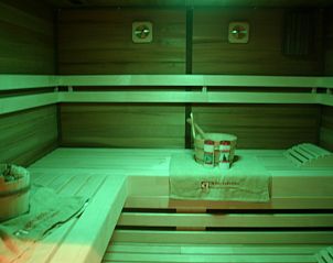 Spacious sauna with green lighting in Herresbach vacation home, Ardennes, Belgium.