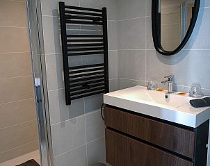 Moderne badkamer in Vrijstaande woning in Spa, vakantiehuis in de Ardennen, Belgi, met stijlvolle wastafel en spiegel.