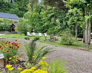 Weelderige tuin van Kasteelvilla Santa Maria in Spa, Ardennen, Belgi, met kleurrijke bloemen en ontspannende zitplaatsen.
