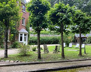 Rustige tuin van Kasteelvilla Santa Maria in Spa, Ardennen, Belgi, met schaduwrijke bomen en comfortabele ligstoelen.