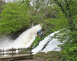 Verken de natuurlijke schoonheid rond vakantiehuis ARD011 in Aywaille, Ardennen, met een indrukwekkende waterval in het groene landschap.