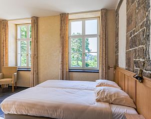 Gezellige slaapkamer in vakantiehuis ARD197, Aywaille, Ardennen, met rustiek stenen muur en uitzicht op de groene natuur van Luik, Belgi.