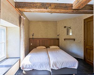 Gezellige slaapkamer in vakantiehuis ARD198, Aywaille, Ardennen, Belgi, met rustieke houten balken en veel natuurlijk licht.