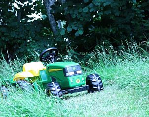 Play tractor on the lawn at Holiday home in Ottr, a charming vacation home in the green nature of the Ardennes, Lige, Belgium.