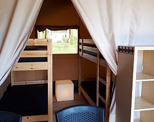 Gezellige binnenruimte van de Safaritent in Deidenberg, Ardennen, Belgi, met stapelbedden en uitzicht op de groene omgeving.