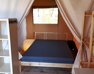 Gezellige slaapkamer in Safaritent, een glamping lodge in Deidenberg, Ardennen, Belgi, met comfortabele bedden en natuurlijke lichtinval.