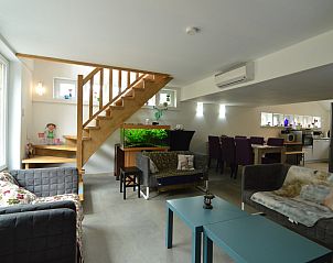 Gezellige woonkamer van vakantiehuis Le coeur du brme in Herbiester, Ardennen, Belgi, met moderne inrichting en sfeervol aquarium.