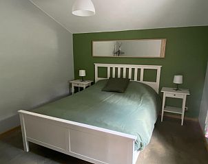 Gezellige slaapkamer in vakantiehuis Le coeur du brme, Herbiester, Ardennen, met comfortabel bed en rustgevende groene muren.