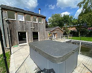 Ontspan in het vakantiehuis Le coeur du brme in Herbiester, Ardennen, met een ruime patio en bubbelbad omringd door groene natuur.