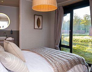 Sfeervolle slaapkamer in The Easy Accessible Leaf, vakantiehuis in Morlies, Henegouwen, Belgi, met uitzicht op de groene natuur.