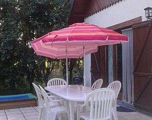 Terrace of Au Vieux Sapin vacation home in Felenne, Ardennes, Belgium with table and umbrella.