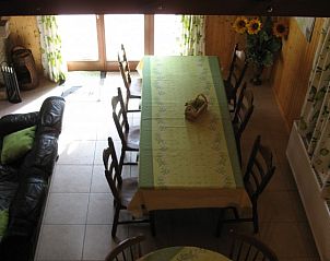 Cozy dining room of Au Vieux Sapin vacation home in Felenne, Ardennes, Belgium with long table.