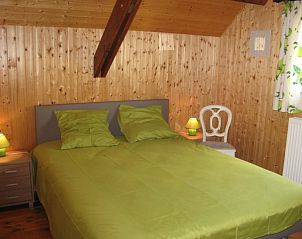 Master bedroom of Au Vieux Sapin vacation home in Felenne, Ardennes, Belgium with wooden interior.