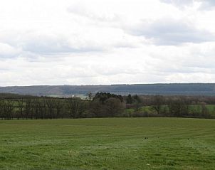 View of green fields surrounding Au Vieux Sapin vacation home in Felenne, Ardennes, Belgium.