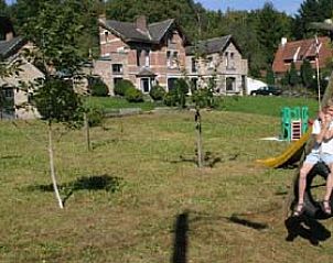 Children play on the swing in the garden of vacation home Windsor in Waulsort, surrounded by nature.