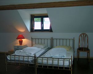 Comfortable bedroom with two beds in vacation home Windsor, located in serene Waulsort, Ardennes.
