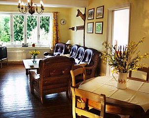 Attractive living room of Les Gronsarts Vencimont vacation home with wooden furniture and large windows in Ardennes, Belgium.