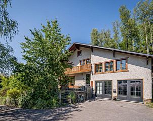 Enjoy the terrace of Lora Cosy vacation home in Membre, Ardennes, overlooking the green hills and an inviting garden.