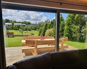 Terrace with wooden picnic table and views of nature at Gite Entre Roches et Nature, vacation home in Dinant, Ardennes, Belgium.