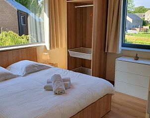 Bright bedroom with wooden interior in Gite Entre Roches et Nature, vacation home in Dinant, Ardennes, Belgium.