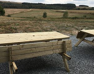 Buitenruimte van Petithalleux6 vakantiehuis in La Roche, Ardennen, met houten picknicktafels en uitzicht.