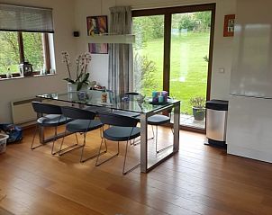 Dining room in Holiday home Ardennes, Durbuy, Belgium with glass table and view of the green garden for cozy meals.