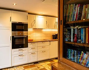 Modern kitchen in Holiday Home in Durbuy, Izier, Ardennes, with stylish cabinets and bookshelf, ideal for a relaxing stay in Belgium.