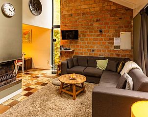 Cozy living room in Holiday Home in Durbuy, Izier, Ardennes, with comfortable sitting area and fireplace, ideal for relaxation.