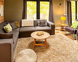 Cozy living room of Holiday Home in Durbuy, Izier, with comfortable seating area and views of the green surroundings of the Ardennes, Belgium.