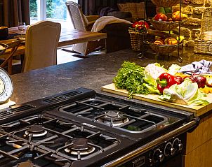 Cozy kitchen of Huisje in Houffalize, vacation home in the Ardennes, Belgium, with a rustic atmosphere and fresh ingredients on the counter.