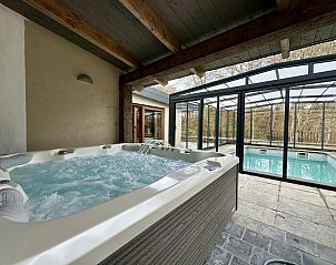 Ontspan in de luxe jacuzzi van Ry de Belle Rose, een vakantiehuis in Grupont, Ardennen, met uitzicht op het binnenzwembad en de omliggende natuur.