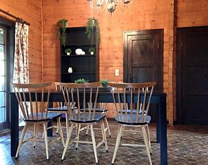 Dining area of Chalet Ma Reine in Remouchamps, Ardennes, with wooden interior and mood lighting.