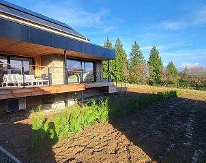 Veranda van Huisje in Grandmenil, gelegen in de Ardennen, Belgi, met uitzicht op groene natuur en een zonnige tuin.