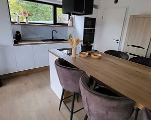 Moderne keuken van Huisje in Grandmenil, vakantiehuis in de Ardennen, Belgi, met houten eettafel en uitzicht op de groene omgeving.